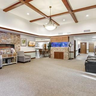 A modern lobby with comfortable seating, a fireplace, and stylish wood beam ceiling.