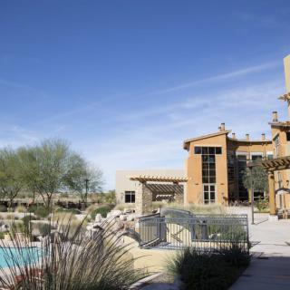 A luxurious resort with a pool set in a desert landscape.