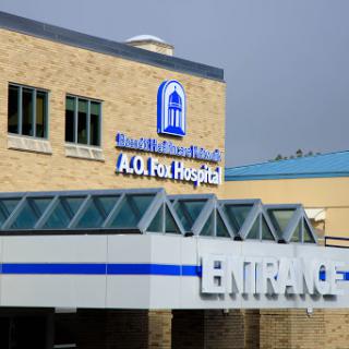 The entrance of a healthcare facility, showcasing the hospital's name prominently.