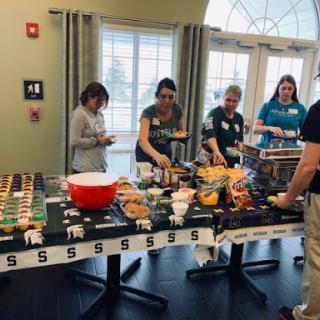 A group of people enjoying a variety of snacks at an event.