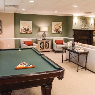 A cozy game room featuring a pool table, comfortable seating, and stylish decor.