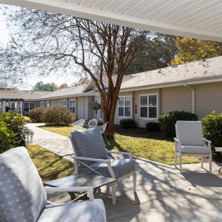 A peaceful courtyard with outdoor seating and a well-maintained garden on a sunny day.