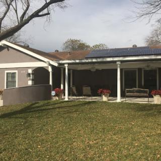 A cozy house featuring solar panels and a welcoming outdoor space.