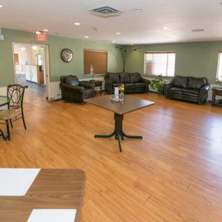 A spacious living room with sofas, chairs, tables, and hardwood flooring.