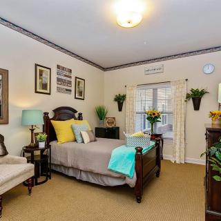 A cozy and well-decorated bedroom with stylish furniture, plants, and artwork.