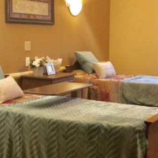 A cozy bedroom with two neatly made beds and a shared nightstand.