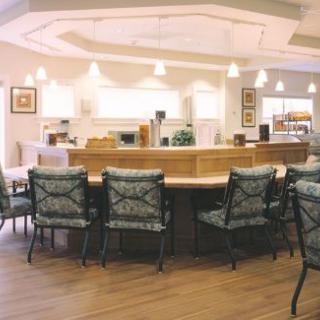 An empty seating area in a restaurant with chairs arranged around a counter.