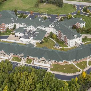 Aerial view of a large building complex with green roofs and surrounding landscaping.
