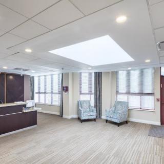 A spacious and well-lit office lobby with a reception desk and seating area.