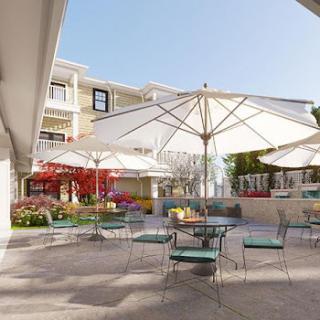 A serene outdoor patio area featuring umbrellas and comfortable seating, ideal for relaxation on a sunny day.