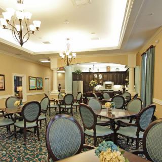 A well-furnished dining room with elegant chairs and tables, featuring a chandelier and classic decor.