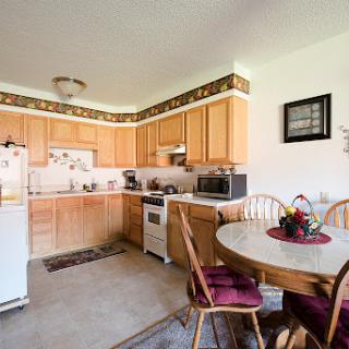 A cozy and functional kitchen featuring wooden cabinets, modern appliances, and a dining area.