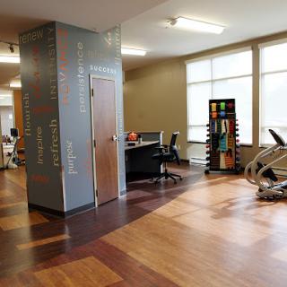 An inviting gym space featuring exercise equipment and a workspace, designed for fitness and well-being.