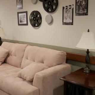 A cozy living room with a plush sofa, decorative wall art, and ambient lighting.