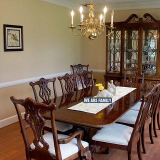 Elegantly furnished dining room with a large table and chandelier.