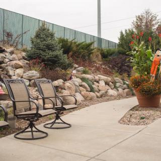 A landscaped patio area with chairs, surrounded by rocks and plants.