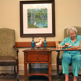 An elderly woman engaged in a leisure activity in a cozy indoor setting.