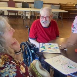 A group of people enjoying an art activity together at a table.