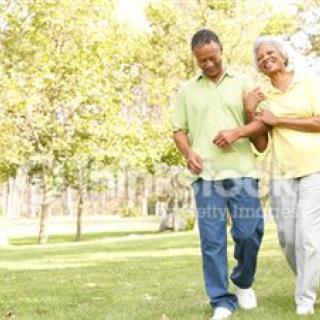 An elderly couple walking together in a park.