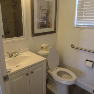Small bathroom with a sink, toilet, and wall decorations.