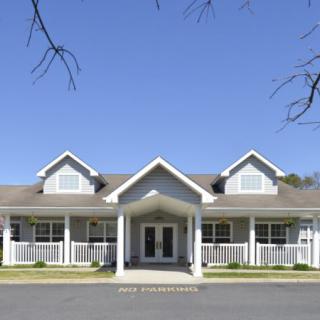 A front view of a residential building with a symmetrical design under a clear blue sky.