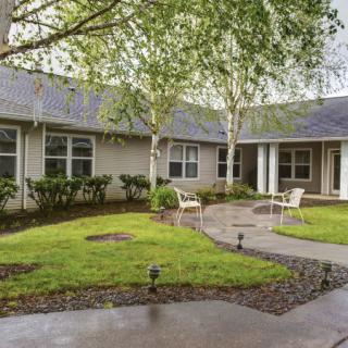 A peaceful courtyard with a garden and pathway surrounded by a building.