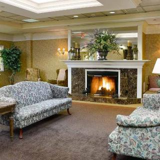 A cozy living room featuring a fireplace, floral sofas, and elegant decor.