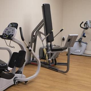 A small gym room with various exercise machines for fitness activities.
