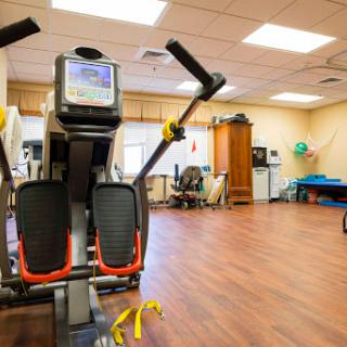 A well-equipped fitness room featuring an exercise machine designed for rehabilitation and training.