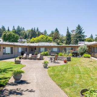 A courtyard with outdoor seating and well-maintained landscaping under a clear blue sky.