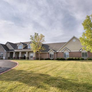 A large suburban house with a well-maintained lawn and driveway.