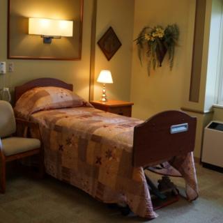 A cozy and well-lit hospital room with a single bed and decorative elements.