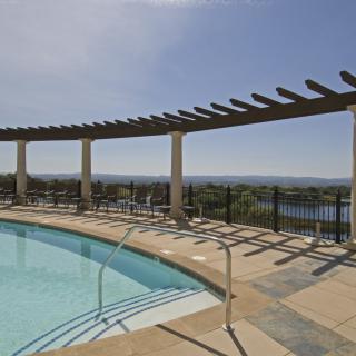 A scenic outdoor pool area with a pergola and panoramic views.