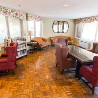A cozy living room with comfortable seating, wooden floors, and large windows.