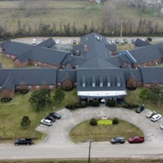 Aerial view of a large residential facility with a circular parking area.