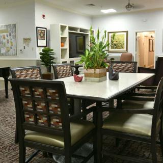 A cozy indoor living area with a table, chairs, and decorative plants.