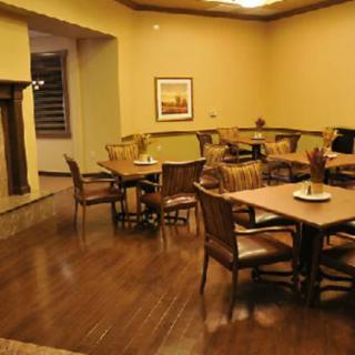 A cozy, warmly lit dining area with wooden tables and chairs.