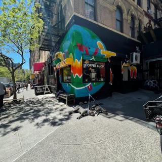 A vibrant mural adorns the exterior of a restaurant, adding color to the bustling city street.