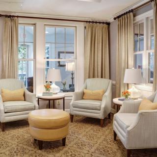 A cozy living room with armchairs, a round coffee table, and elegant lighting.