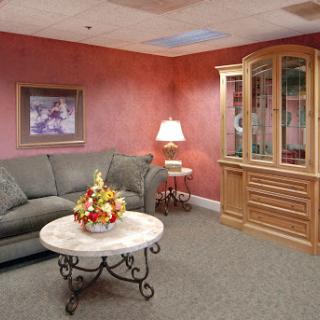A cozy living room featuring a green sofa, decorative coffee table, and warm-colored walls.