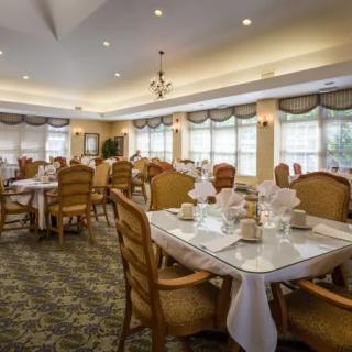 A spacious and elegantly decorated dining room with neatly arranged tables and chairs.