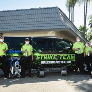 Members of the Strike Team for Infection Prevention pose in front of their vehicle, showcasing their commitment to health and safety.