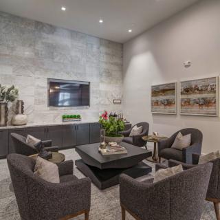 A modern living room with contemporary furniture and decor, featuring a television and wall art.