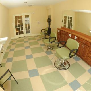 An empty hair salon interior with barber chairs and a reception desk.