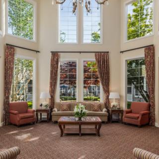 A cozy living room with large windows, stylish curtains, and comfortable seating.