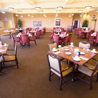 A spacious dining room with neatly set tables and chairs, ready for guests.