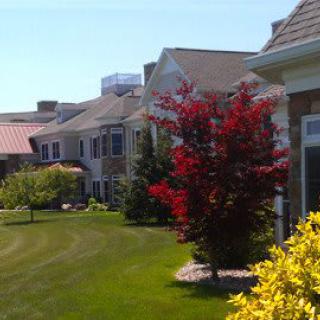 A suburban neighborhood with well-maintained lawns and colorful trees.