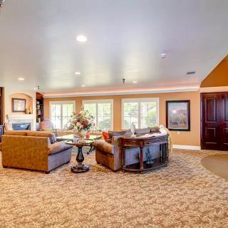 A spacious and bright living room with comfortable sofas, a central table, and large windows.