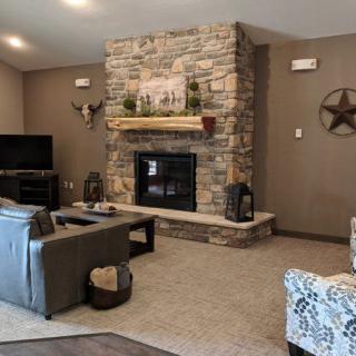 A cozy living room with a stone fireplace and rustic decor.