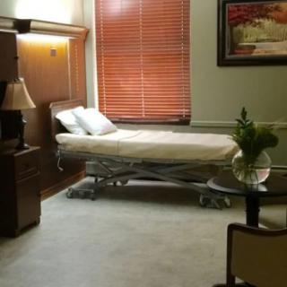 A well-decorated hospital room with a single bed near a window.
